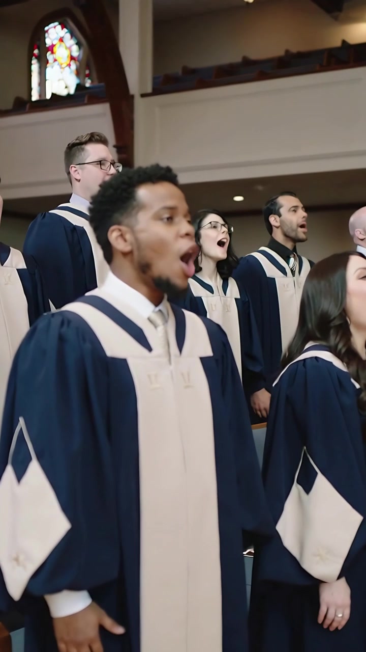 Vertical video: Singing lead singer following conductor cue, projecting hymn at church in navy robe