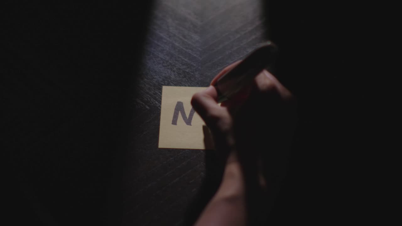 "No" written on a Sticky Note with a sharpie and placed on a table under dramatic lighting