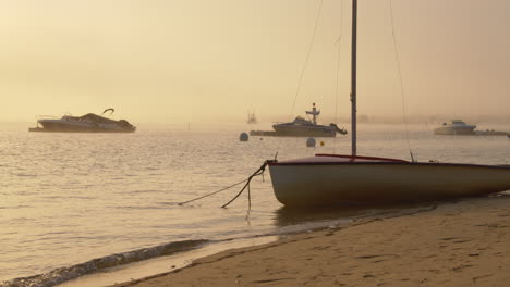 beautiful misty golden sunrise overlooking the ocean and moored boats.