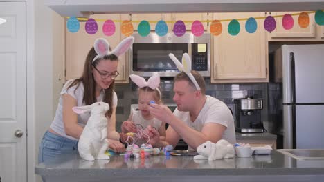 family happily paints and decorates eggs for the holiday. easter traditions