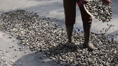 los trabajadores raspaban grava antes de pavimentar la carretera