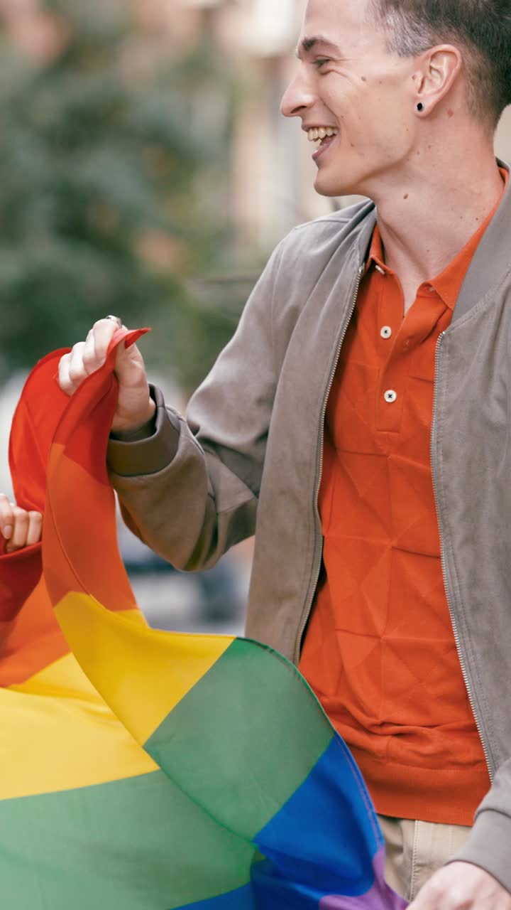 Man holding a rainbow flag at a pride parade