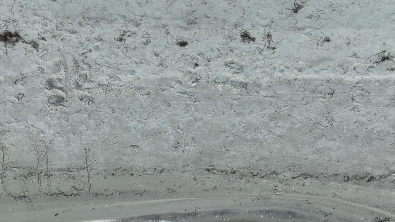 해안선이 보이는 모래 해변의 공중, 위에서 아래로 볼 수 있습니다.