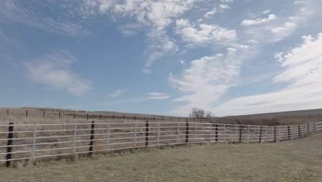 wooden fence on a pastoral farmland under a blue sky