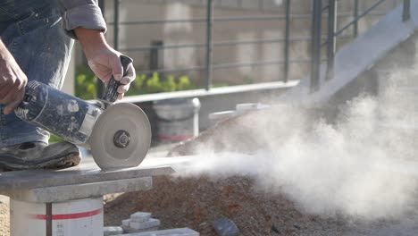 construction worker using an angle grinder to cut stone