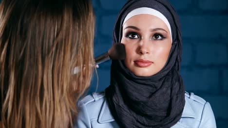 makeup application on a woman wearing a hijab