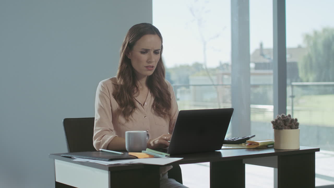 Donna d'affari che riceve brutte notizie. Una donna freelance seria lavora al computer portatile.