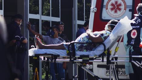 paramedics unload pregnant patient from ambulance during the covid-19 pandemic