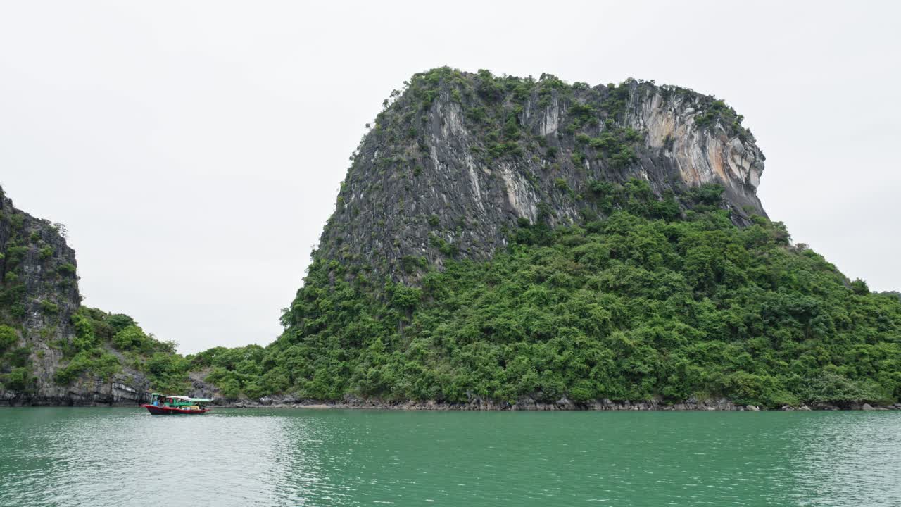 베트남 의 석회암 숲 산맥 을 배경 으로 한 하롱 만 에서 전통적 인 보트 항해