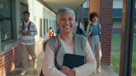 a woman smiles in a school hallway with students in the background