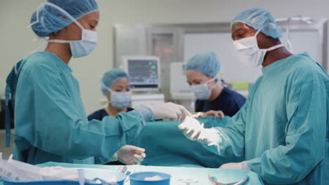 Nurse-Hands-Surgeon-Medical-Instruments-As-Surgical-Team-Work-On-Patient-In-Operating-Theatre