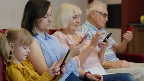 addicted to gadgets family using mobile phone, tablet, laptop ignoring each other at home