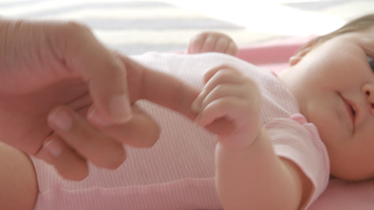 슬로우 모션으로 핑크색 담요에 누워 있는 아기 소녀