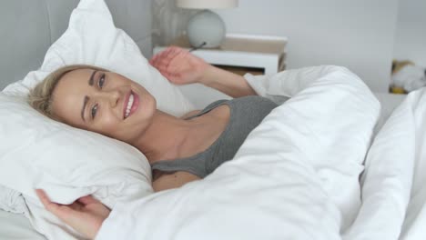 joven y bella mujer rubia durmiendo en su dormitorio