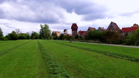 un dron vuela bajo sobre un prado verde hasta la hermosa vista aérea de la ciudad antigua