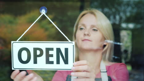 the female seller turns the tablet that says closed to open beginning of the day open your business