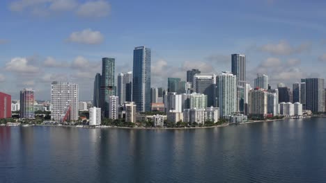 aerial shot of downtown miami from biscayne bay slowly moving towards the city from a low to higher altitude