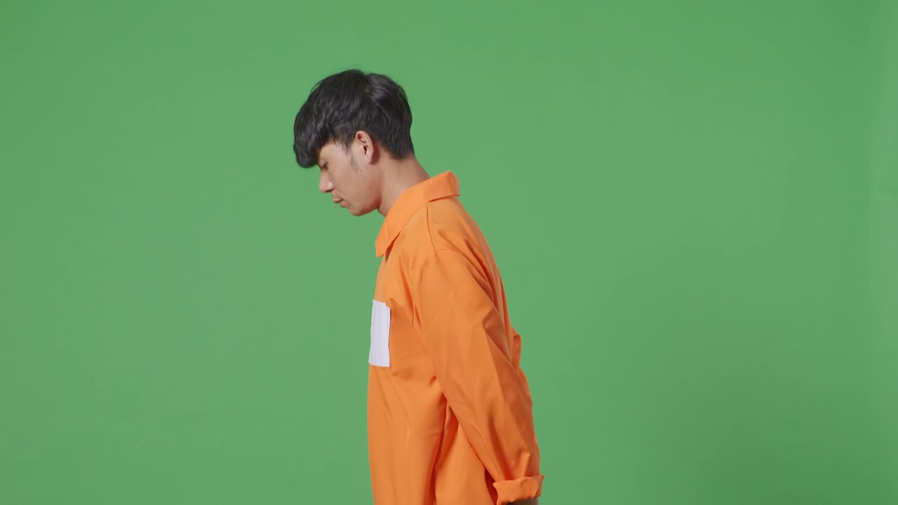 녹색 스크린 배경에서 손을 고 있는 아시아 남성 죄수