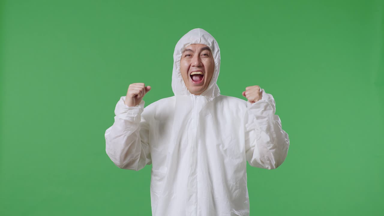 아시아 남성 과학자가 녹색 화면 배경에 서서 성공을 축하하고 있습니다.