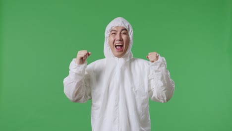 아시아 남성 과학자가 녹색 화면 배경에 서서 성공을 축하하고 있습니다.