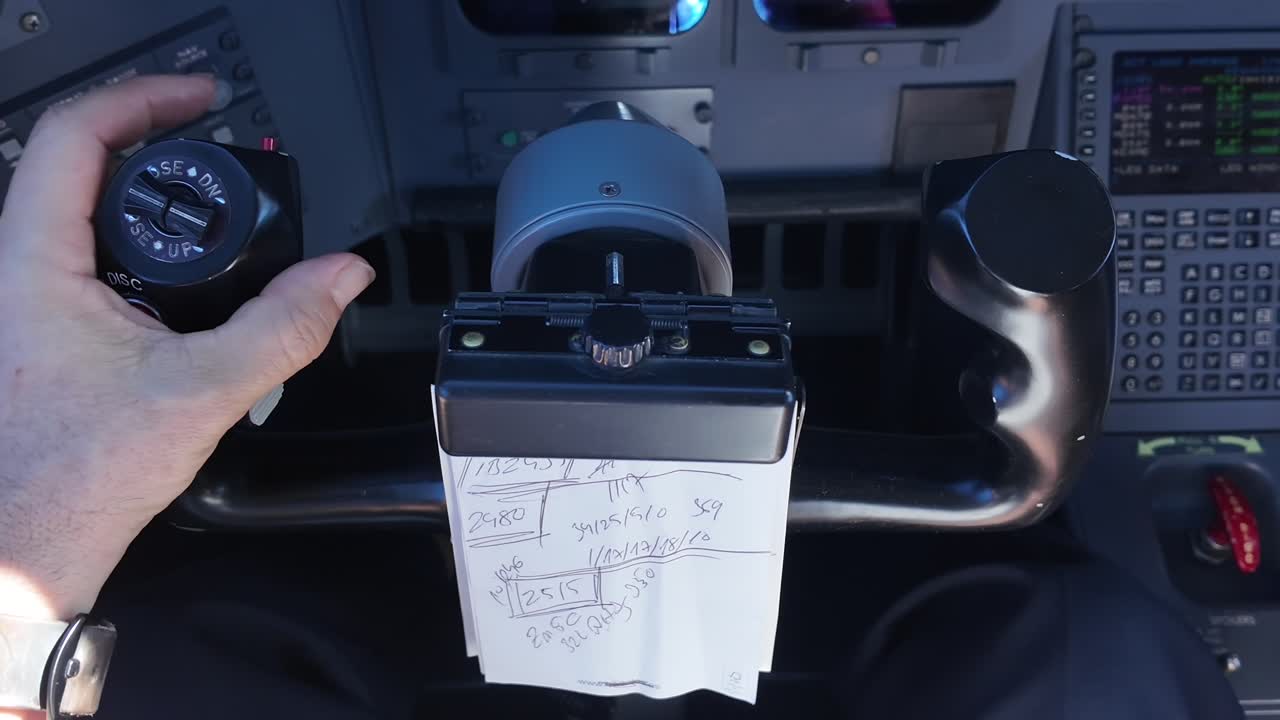Closeup view of the left hand of a pilot (Captain) flying manually the flight controls of a modern jet, in a cockpit bathed in sunlight. High-angle shot