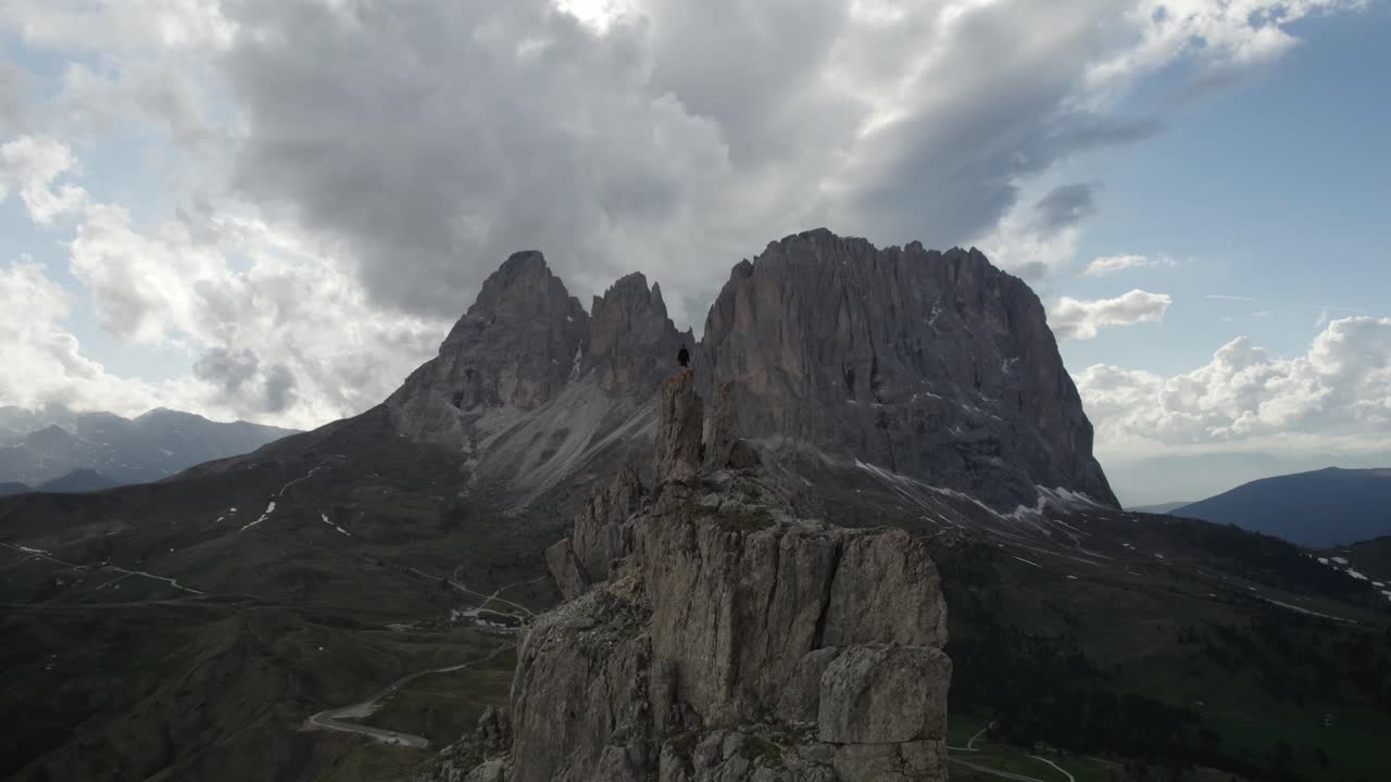 tiro de drone de una persona en la cima de la montaña en passo sella en val gardena italia-1