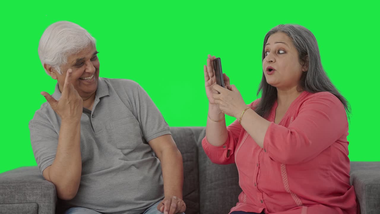 귀여운 은 인도인 아내가 남편의 사진을 클릭하는 녹색 화면