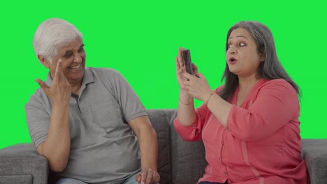 Cute-Old-Indian-wife-clicking-pictures-of-her-husband-Green-screen