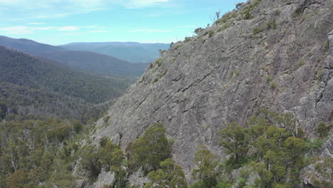 aerial retreats from steep, craggy sugarloaf peak in victoria, aus