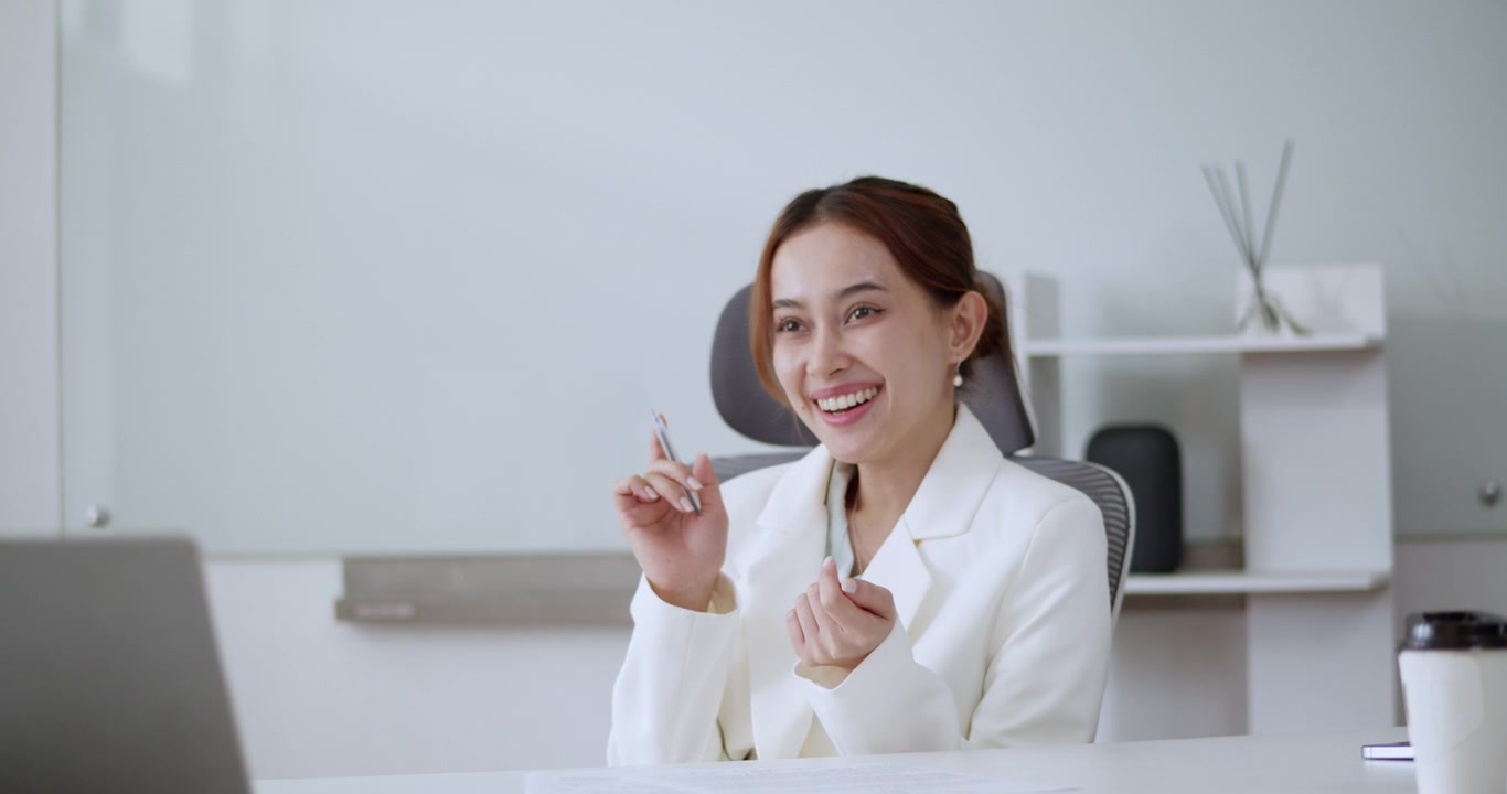 Una donna d'affari allegra partecipa attivamente a una riunione virtuale, mostrando professionalità e coinvolgimento