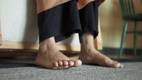 barefoot legs and feet resting on the floor.