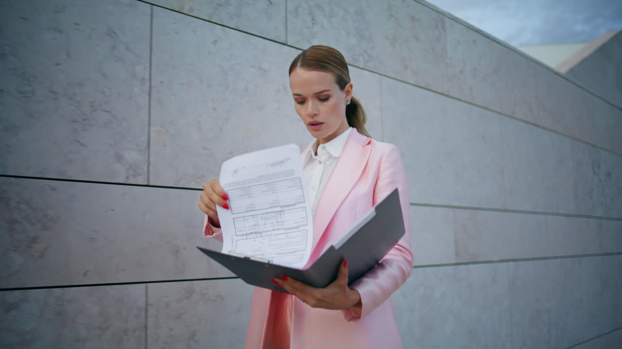 Businesswoman walking checking documents in folder close up. Lady reading report