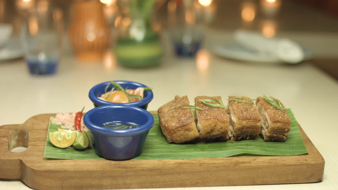 plato de lechon crujiente con un fondo de luz de vela 4k