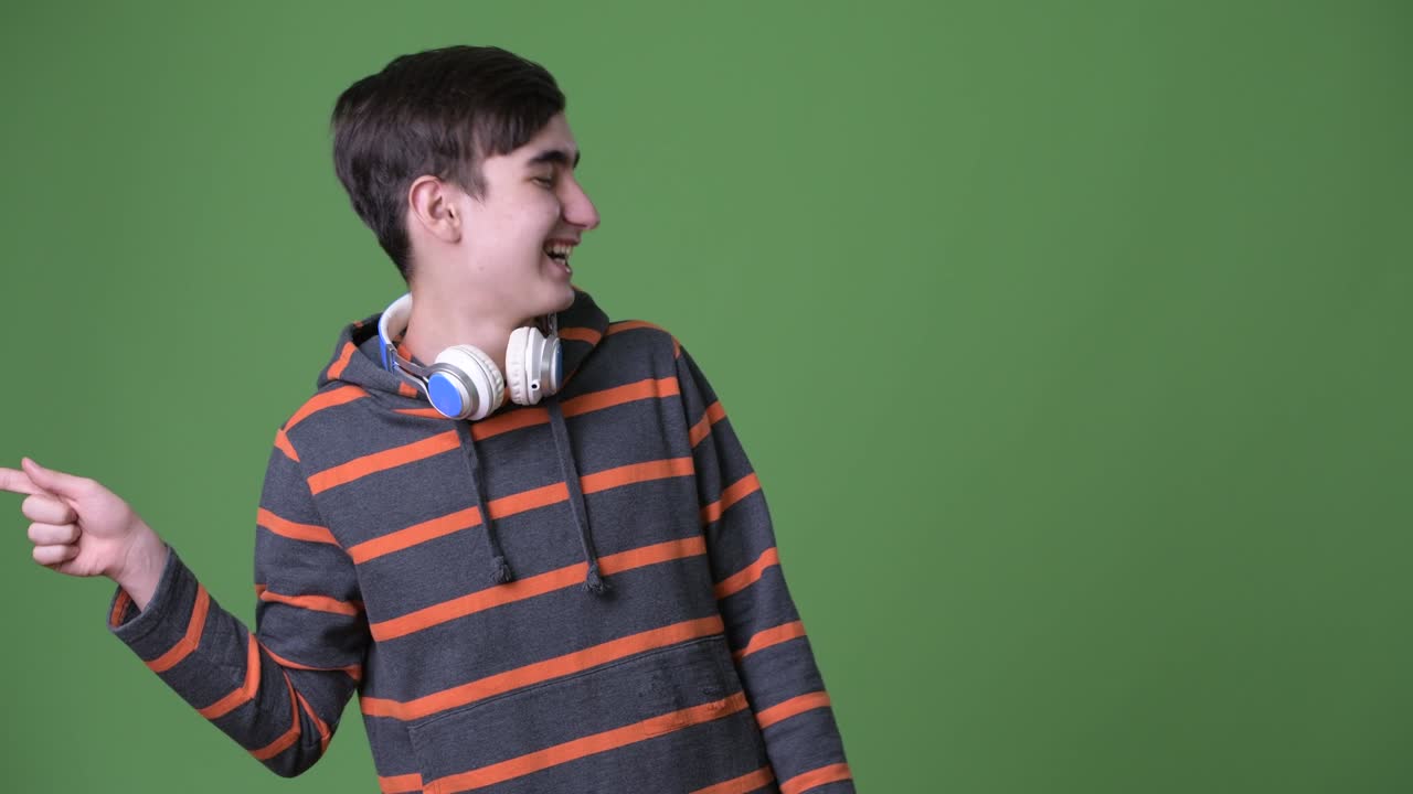 joven y guapo adolescente iraní contra un fondo verde