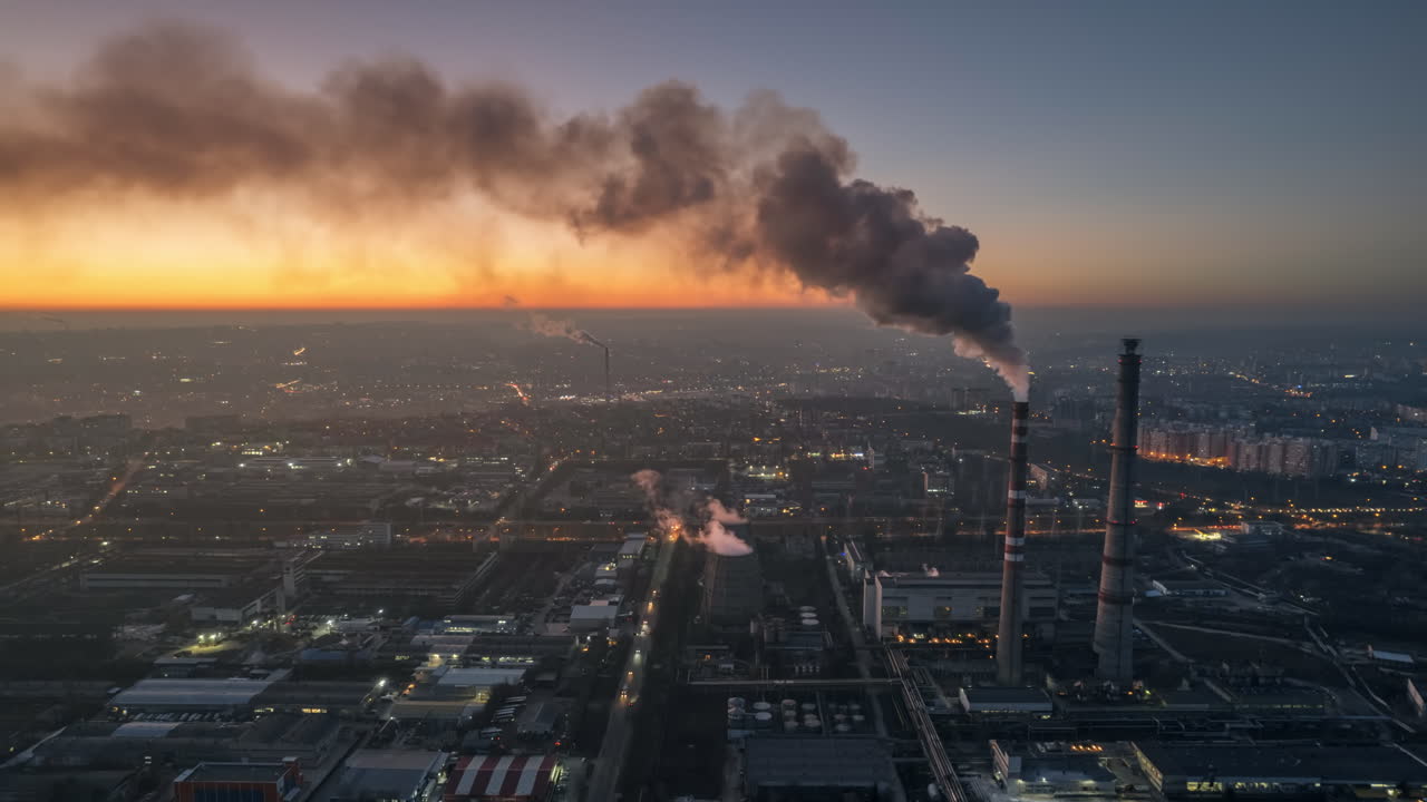 Aerial drone timelapse view of thermal power plant in Chisinau at sunset, Moldova. View of pipes with felling steam, cityscape