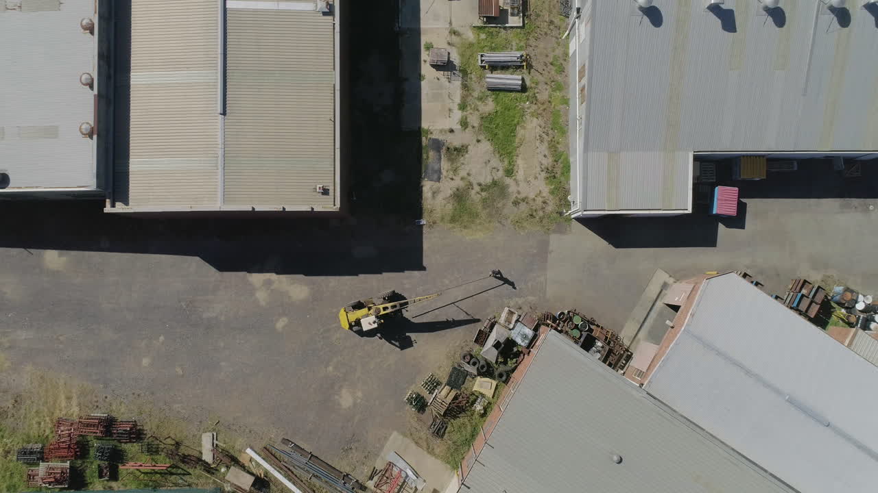 grúa móvil amarilla que mueve una viga de metal pesado a la fábrica para un mayor refinamiento