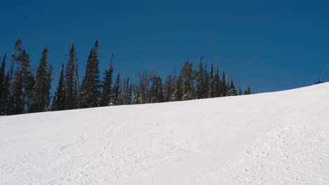 a skier on a nice day skiing fast on a groomed run in big sky montana