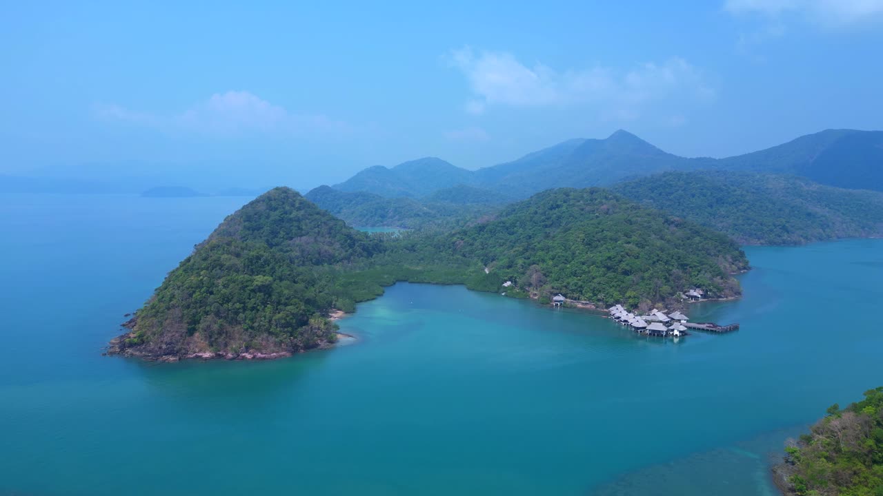 Koh Chang's Ko Ngam idyllic landscape, featuring lush greenery, a pristine beach, and a tranquil pier extending into the turquoise waters. Beautiful aerial view flight panorama overview drone