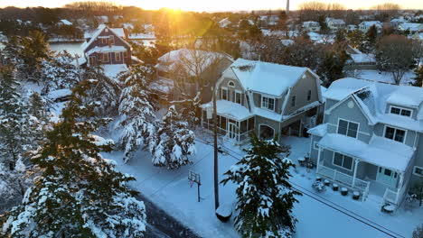 snow covered homes and trees at sunrise