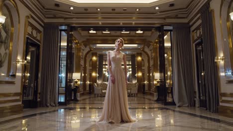 woman in a beige gown in a luxury hotel hall