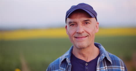 positive adult farmer smiling into camera at field agriculture 2