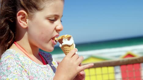 chica tomando helado en la playa