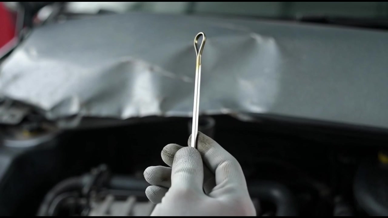 Mechanic Checking Car Engine Oil Level With Dipstick