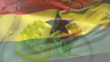 ghana flag animation overlaying fresh salad with tomatoes and lettuce on plate