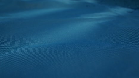 a serene water surface with gentle ripples and glistening raindrops in calming blue hues, creating peace
