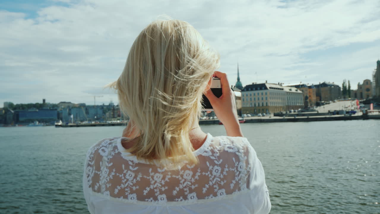 젊은 관광객이 복고풍 카메라로 스톡홀름의 아름다운 전망을 촬영합니다.