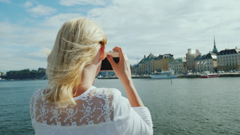 a young tourist photographs beautiful views of stockholm with a retro camera