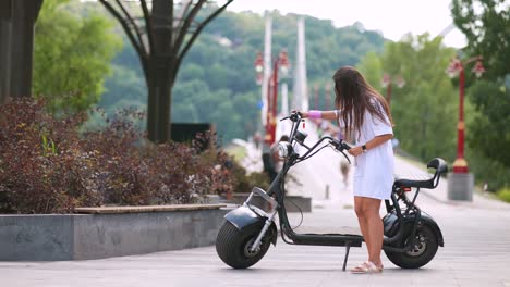 woman riding an electric scooter in a city park