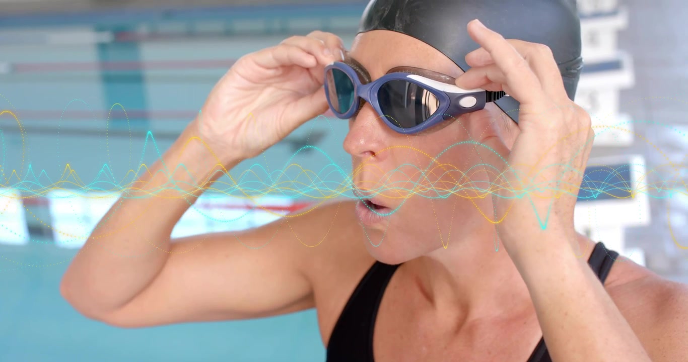 Nuotatrice agonistica matura che solleva gli occhialini a bordo piscina, regolando la cinghia per l'allenamento di nuoto in corsia.