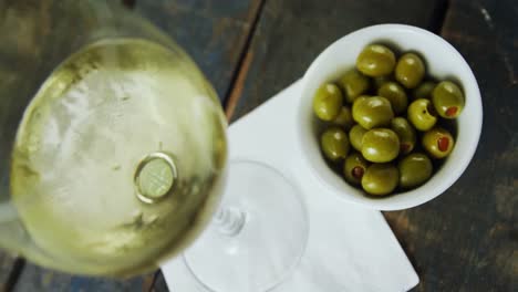 glas wein und oliven auf dem tisch